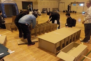 ダンボールベッドを組み立てている写真