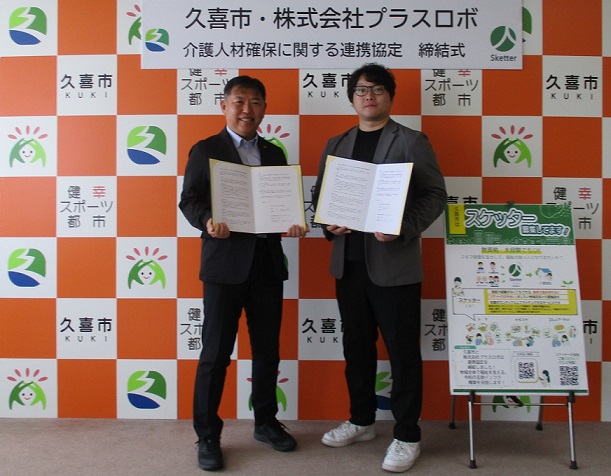 梅田市長と鈴木亮平社長が協定書を持っている写真