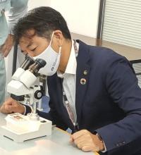 顕微鏡をのぞく梅田市長